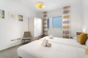 a bedroom with two white beds and a window at Villa Aurora Playa La Arena in Puerto de Santiago +36 photos