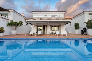 a swimming pool in front of a house at Villa Aurora Playa La Arena in Puerto de Santiago