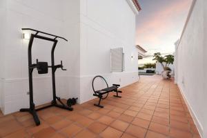 a gym with a treadmill and a bench in a room at Villa Aurora Playa La Arena in Puerto de Santiago