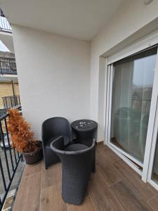 a balcony with two chairs and a table at OnPoint Apartmani in Osijek