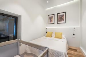 a white room with a bed with yellow pillows at Casa Miranda 3 in Igueste