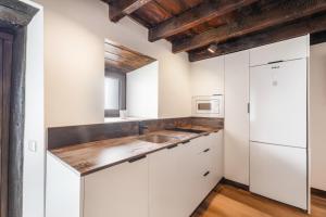 a kitchen with white cabinets and a wooden ceiling at Casa Miranda 3 in Igueste