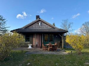 a house with a table and chairs in front of it at Wooden Western Lodge Tiny Haus in Brekendorf