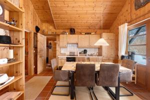 a kitchen with a table and chairs in a cabin at Wooden Western Lodge Tiny Haus in Brekendorf