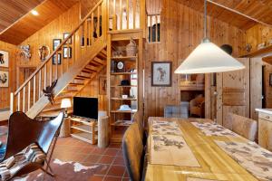 a dining room with a table and a staircase at Wooden Western Lodge Tiny Haus in Brekendorf