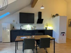 a kitchen with a wooden table and a refrigerator at moselquartier terlinden- Loft in Perl +18 photos