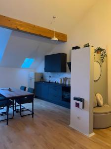 a kitchen and dining room with a table and a refrigerator at moselquartier terlinden- Loft in Perl