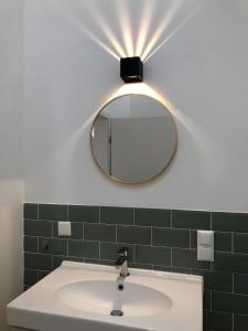 a light above a bathroom sink with a mirror at moselquartier terlinden- Loft in Perl