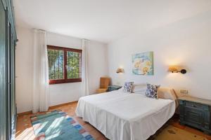 a bedroom with a white bed and a window at Roc Blau in Begur +37 photos
