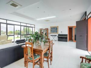 a kitchen and living room with a wooden table and chairs at Villa Germano con piscina in Solarino