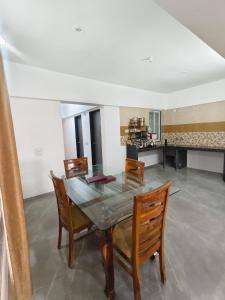 a dining room with a glass table and chairs at Hotel Vaishnavi Heights, Solapur in Bāle