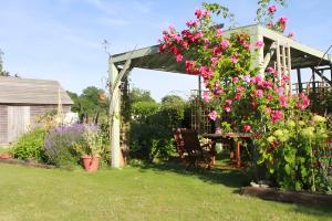 a garden with a gazebo with pink flowers at La Morinière in Vieux
