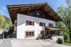 a large white house with a wooden roof at Mayrhof Zimmer, Bauernhofurlaub in San Pancrazio dʼUltimo