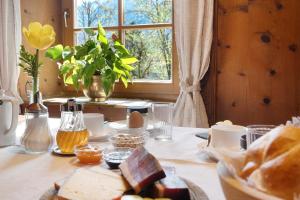 a table with a plate of bread and a window at Mayrhof Zimmer, Bauernhofurlaub in San Pancrazio dʼUltimo