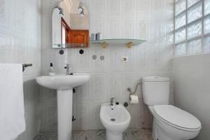 a white bathroom with a toilet and a sink at Jalón de Cameros in Tacoronte +18 photos
