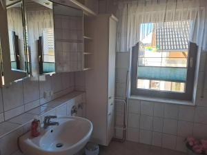 a bathroom with a sink and a mirror and a window at Zweiraum-Ferienwohnung Mitte in Marienberg