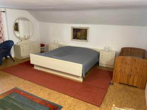 a bedroom with a bed and two dressers and a mirror at Ferienhaus Winter in Blaibach