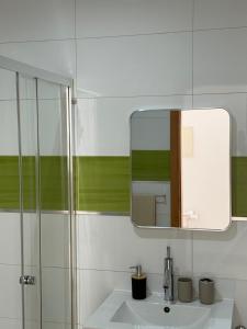 a bathroom with a sink and a mirror at Urban Praia Maria - ApartHotel in Praia +68 photos