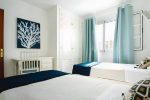 a bedroom with two beds and a window at Bungalow 7 - Caleta Campos in Arrieta
