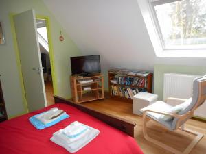 a bedroom with a red bed and a tv at Chambre De Convenant Hery Bihan in Coatreven