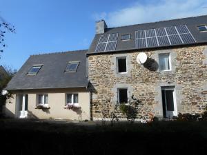 a stone house with solar panels on the roof at Chambre De Convenant Hery Bihan in Coatreven