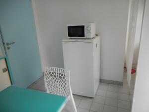 a white refrigerator with a microwave on top of it at Chambre De Convenant Hery Bihan in Coatreven