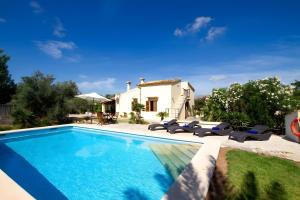 a villa with a swimming pool in front of a house at Villa L´Embat in Pollença +6 photos