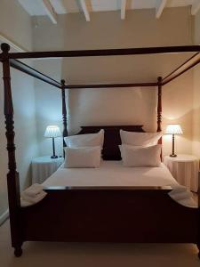a bedroom with a bed with two lamps on two tables at De Kothuize 18 in Graaff-Reinet