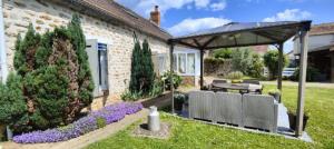 a garden with a patio with a table and a pavilion at Les Chambres De Martine Et Guy - in Sermaise