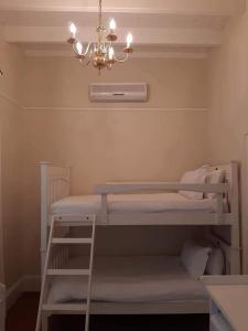 a room with two bunk beds and a chandelier at De Kothuize 18 in Graaff-Reinet