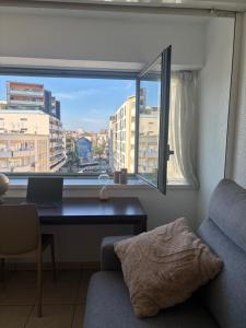 a room with a desk with a laptop and a window at La nuit Douce in Annemasse