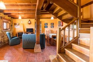 a living room with wooden stairs and a dining room at Casa Alba in Bárcena de Cicero
