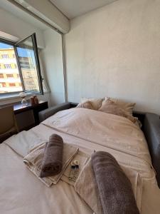 a bedroom with a bed with towels on it at La nuit Douce in Annemasse