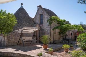 an external view of a stone house with an umbrella at Villa Trullo Vecchia Aia in Alberobello