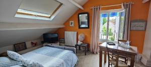 a bedroom with a bed and a desk and a window at Les Chambres De Martine Et Guy - in Sermaise