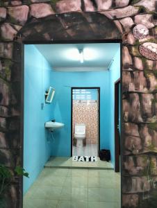 a bathroom with a toilet and a blue wall at Happy house in Ban Khlong Son