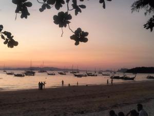 a group of boats on the beach at sunset at Happy house in Ban Khlong Son