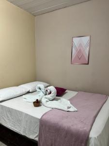 a bedroom with two beds with towels on the bed at Pousada do Delta in Tutóia