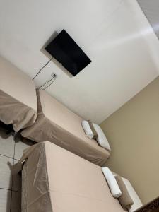a room with two beds and a tv on the ceiling at Pousada do Delta in Tutóia