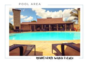 a swimming pool in front of a house at Ol Pejeta Villa in Nanyuki