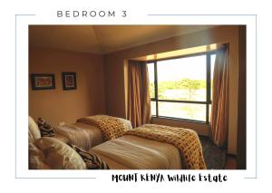 a room with two beds and a window at Ol Pejeta Villa in Nanyuki +63 photos