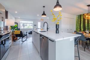 a kitchen with a counter with a vase of yellow flowers at Le Taiga - Pool Table Nature Pet Friendly in Pont-Rouge