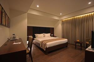 a hotel room with a bed and a desk at Hotel German Palace Near to Airport in Gandhinagar +83 photos
