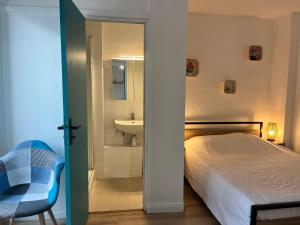a bedroom with a bed and a bathroom with a sink at Bleu Mandarou in Millau
