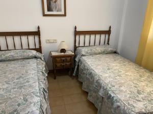 a room with two beds and a night stand with a lamp at Apartamento Platja Mar 2 in L'Escala