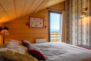 a bedroom with a large bed and a window at Le Chalet Milien in La Bresse