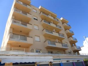 a tall yellow building with a balcony at Apartamento Platja Mar 2 in L'Escala