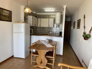 a kitchen with a wooden table and a white refrigerator at Apartamento Platja Mar 2 in L'Escala