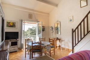 a living room with a table and a television at Duplex in Grosseto-Prugna