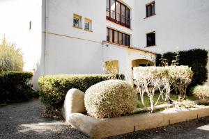 a white building with bushes in front of it at Duplex in Grosseto-Prugna